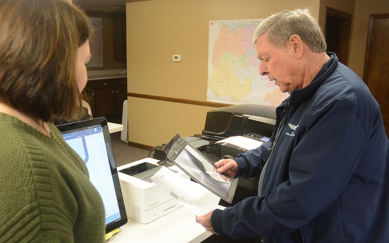 Webb watches as Bishop reviews his ballot on a paper printout. 