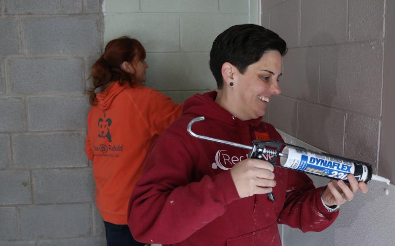 Sunshot by Grayson Williams — RedRover Outreach Manager Katie Campbell, right, and Bryna Donnelly, left, Director of GreaterGood.org’s Rescue Rebuild program, caulk and paint a new indoor kennel area at the Northeast Georgia Council on Domestic Violence’s shelter.