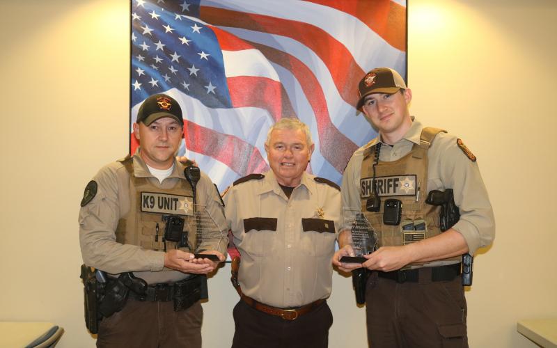 Sunshot by Grayson Williams - Hart County deputies Steve Williams, left, and Matt Sparrow, right, pose for a photo with special plaques presented to them by Hart County Sheriff Mike Cleveland, center, for saving a man’s life. 