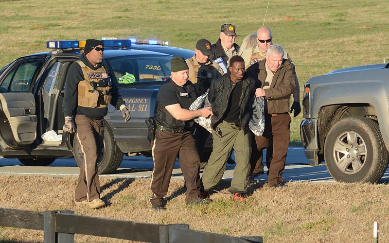 Sunshot by Michael Hall - Hart County Sheriff Mike Cleveland, right, and deputies escort Larrendrick Rashad Tabor, center, from a squad car to an ambulance after his arrest Tuesday, Jan. 28, for his alleged involvement in a Monday night murder in Hart County. 