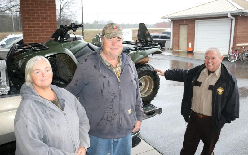 Sunshot by Grayson Williams - Janice Mize, left, and Tim Mize, middle, pose for photo with Sheriff Mike Cleveland at the Sheriff’s office recently with a four-wheeler that was recovered weeks after it was stolen.