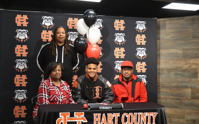 Sunshot by Drew Dotson - Hart County defensive lineman JT Hunt, center, poses for a photo after signing with his father Ronnie Hunt, right, brother Marco Hunt, standing, and mother Jennifer Hunt.