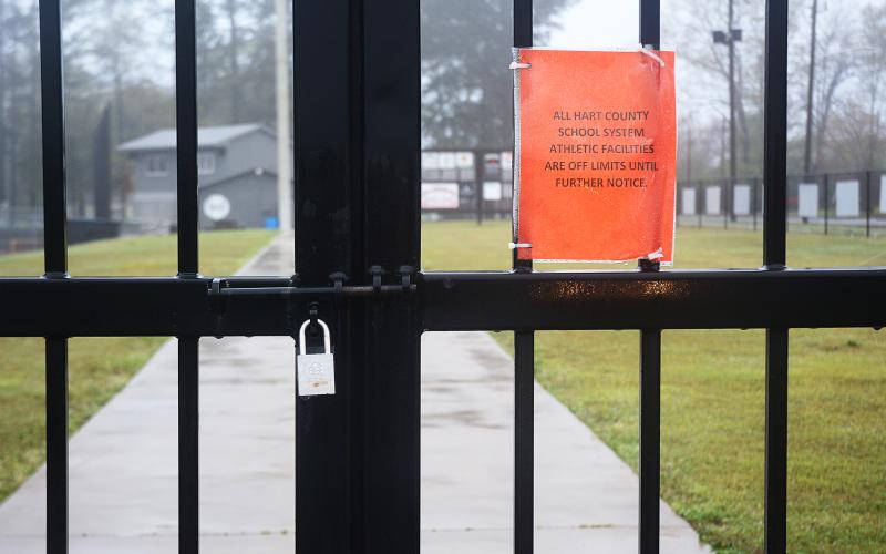 The gate at Saye Field at Hart County High School is locked with a note about the grounds being off limits.