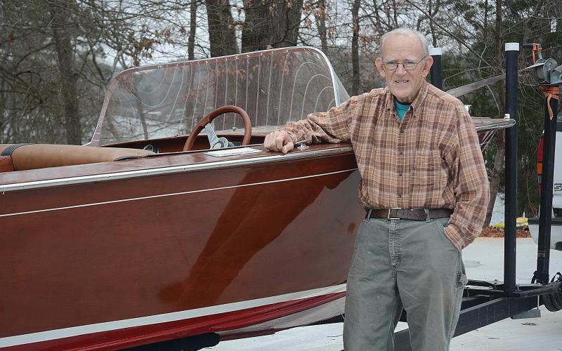 Sunshots by Michael Hall -  Lee Mapp poses for a photo next to his Correct Craft classic boat. 