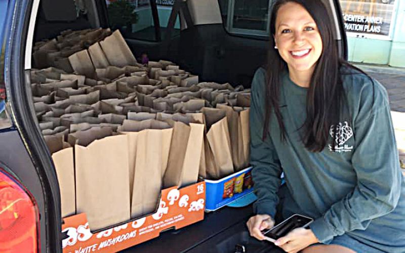 Photo submitted — Raleigh Whitworth poses for a photo with an SUV full of lunches prepared by Southern Hart Brewing Co. ready to deliver to the Nestle-Purina factory in Hartwell.