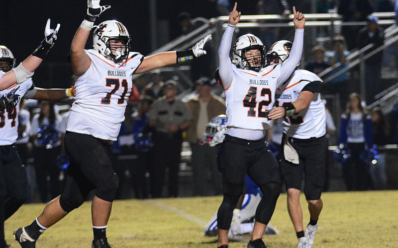 Sunshot by Michael Hall — Hart County kicker Tucker Kim, No. 42, raises his hands in victory along with Caden Hart, No. 71, while quarterback Luke Lee tackles Kim after Kim’s game winning field goal on Nov. 22, 2019 in Blackshear over the Pierce County Bears. 