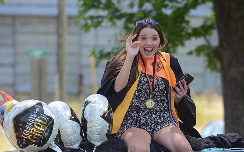 Sunshot by Michael Hall Emma Ayers, a member of the HCHS Class of 2020, waves at her cousins as she passes them during the Parade of Graduates on Saturday, May 23.