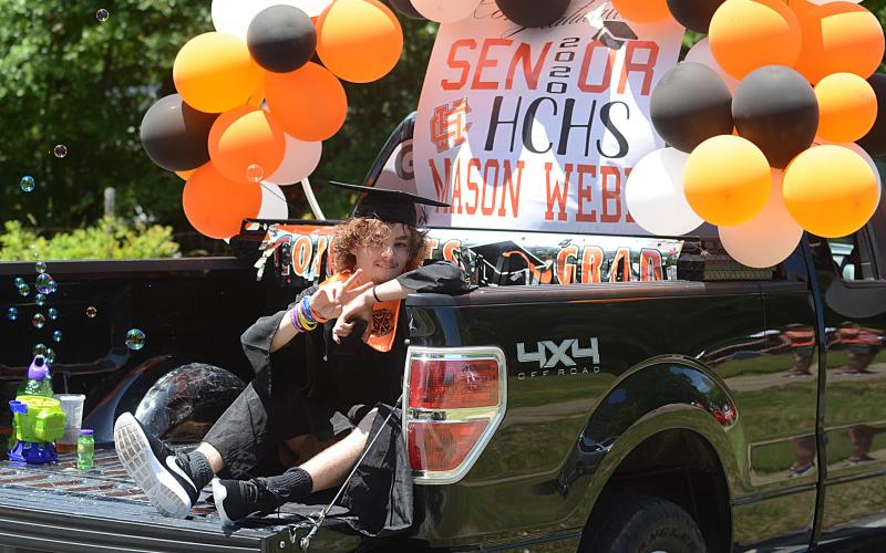 Graduate Mason Webb flashes a peace sign as his truck passes in the parade on May 23.
