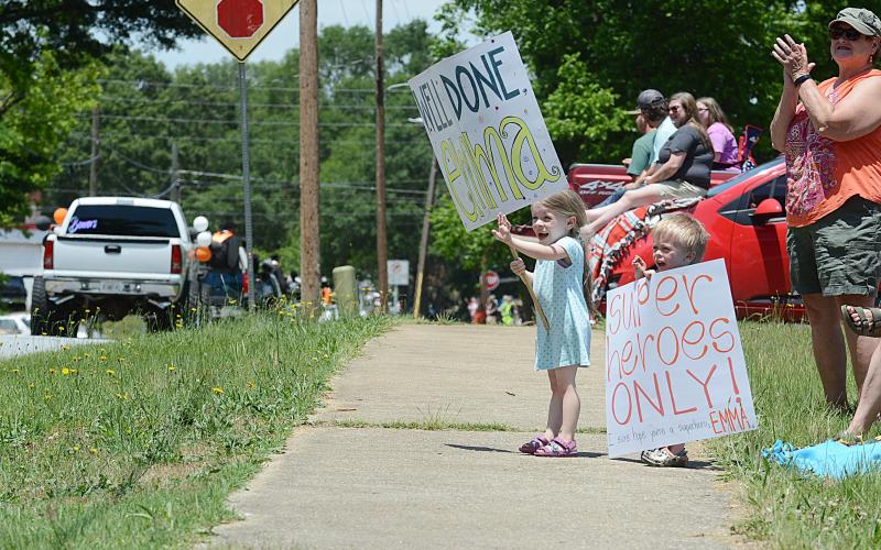 Violet Ayers, left, 6, and Jasper Ayers, 4, right, hold signs in support of their cousin Emma Ayers on Saturday, May 23, during the Parade of Graduates in Hartwell.  Sunshot by  Michael Hall