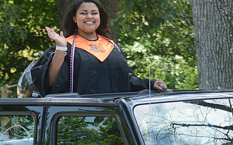 Cheyenne Pettys waves from a pass Jeep during the Parade of Graduates.