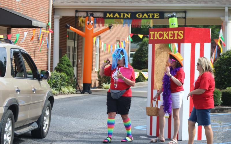 Sunshot by Grayson Williams Vacation Bible school teachers Jennifer Craft, left, Teresa Haygood, middle, and Kelie Worley, right are in costume pass out materials Thursday, June 18, at Hartwell First Baptist, to families participating in this year’s virtual VBS.