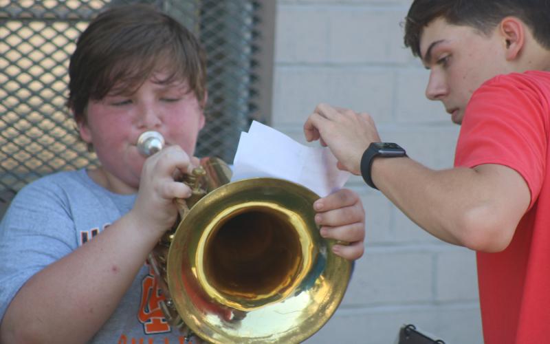 Sunshots by Grayson Williams — Hart County High School band captain Adam Walters, right, helps Caleb Reed, left with his music during the second day of band camp on Tuesday. 