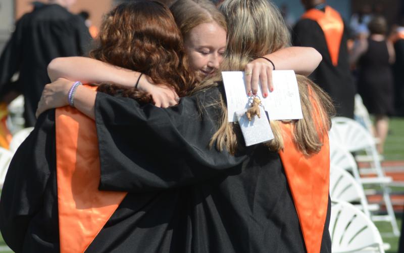 Emma Jones, center, hugs graduates Kate Hobson, left, and Morgan Terrell, right, following Saturday’s ceremony.