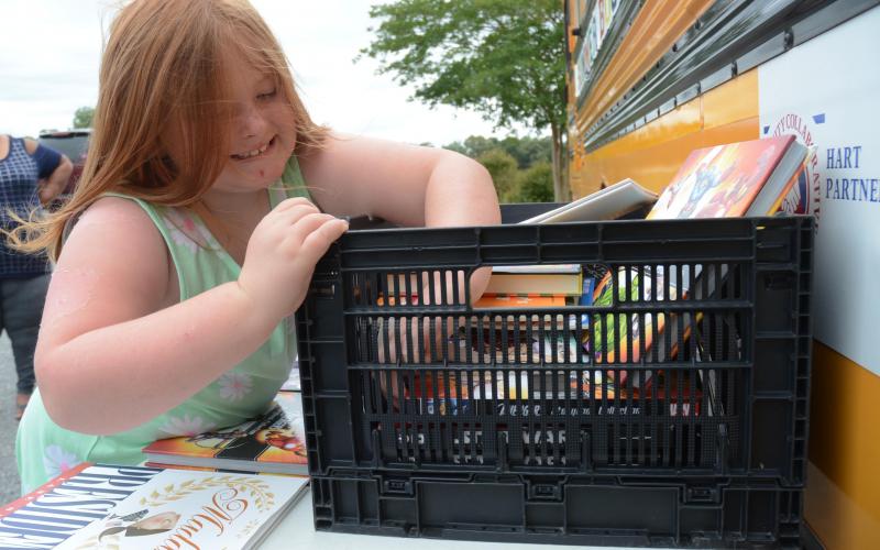 Photo from file — Emily Pickens, 7, finds a Star Wars book Tuesday, June 16, during a stop of the Hart Partners Summer Book Mobile at the Reed Creek Dollar General, for her brother Ethan, 11. 