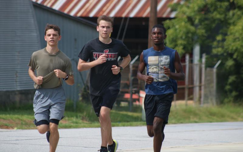Sunshot by Grayson Williams — Colt Risner, Austin Little and Amahd Longworth run recently at Hart County Cross Country practice.