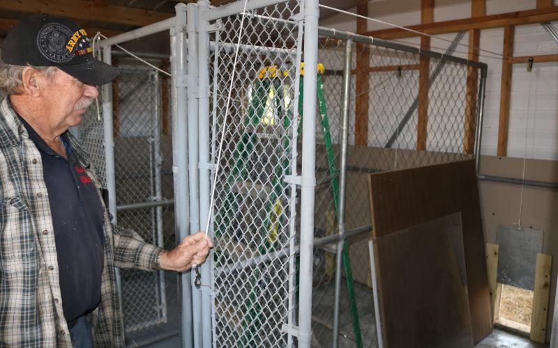 Sunshot by Grayson Williams Denny Noviski pulls the rope to open a dog door in a kennel at the new Hart County Animal Rescue facility on Anderson Highway. 