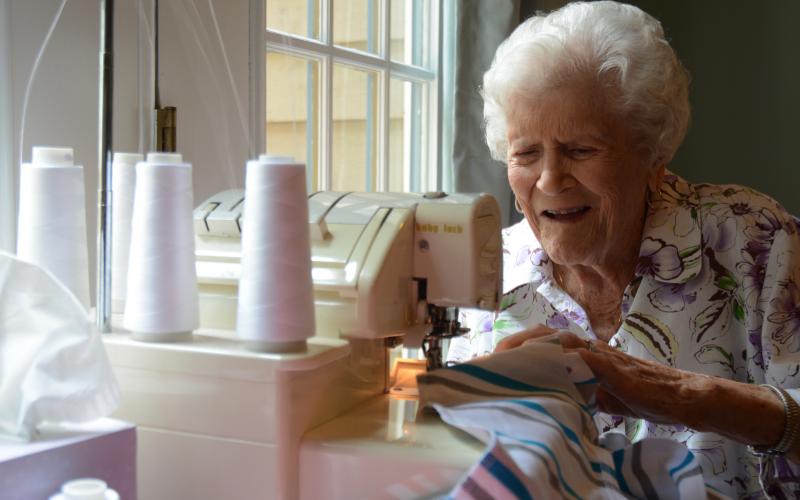 Sunshot by Michael Hall - Doris Mahannah works on a onsie for a newborn at her home in Hart County recently. Mahannah is 104 years old and contributes regularly to Tiny Stitches. 