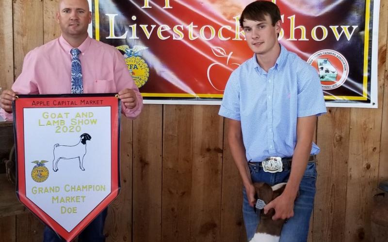 Larson Craft, right, is awarded as 11th-grade showmanship champion and as the grand champion in the doe and wether competition at the Apple Capital Market Goat Show in Ellijay.