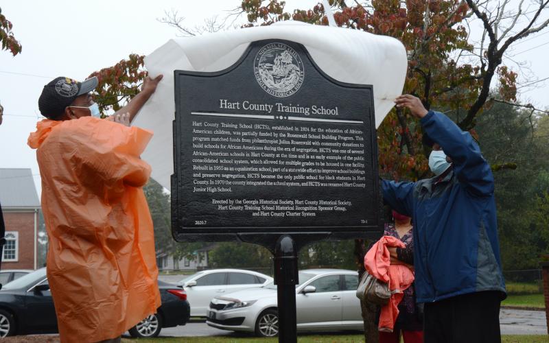 Sunshot by Michael Hall - Thomas Morrison, left, and Michael Partlow, right, unveil the new historical marker from the Georgia Historical Society at the former Hart County Training School on Richardson Street on Oct. 10. 