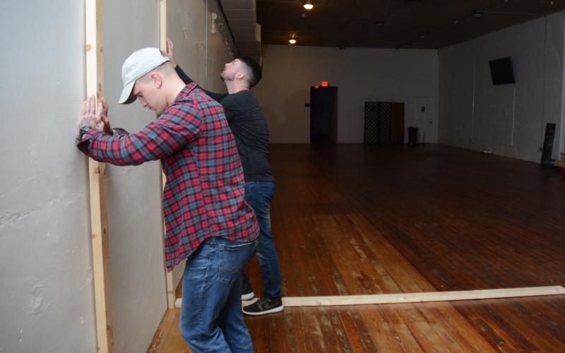 Sunshot by Michael Hall - Andrew Whitworth, left, and business partner Austin Gentry, right, stand lumber up against a wall in the Howell Street building where Sublime Axe Throwing is set to open to show the dimensions of a lane. 