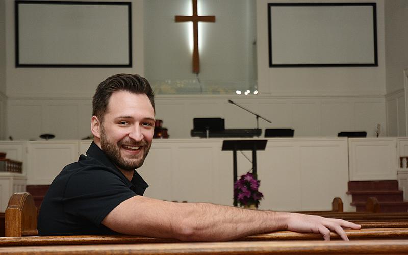 Sunshot by Michael Hall - Cross Roads Baptist Church pastor Sean Payne poses for a photo in the church’s sanctuary, which opened in 1920. The church is celebrating its 150th anniversary this year and is opening a new Family Life Center to mark the occasion on Feb. 14.