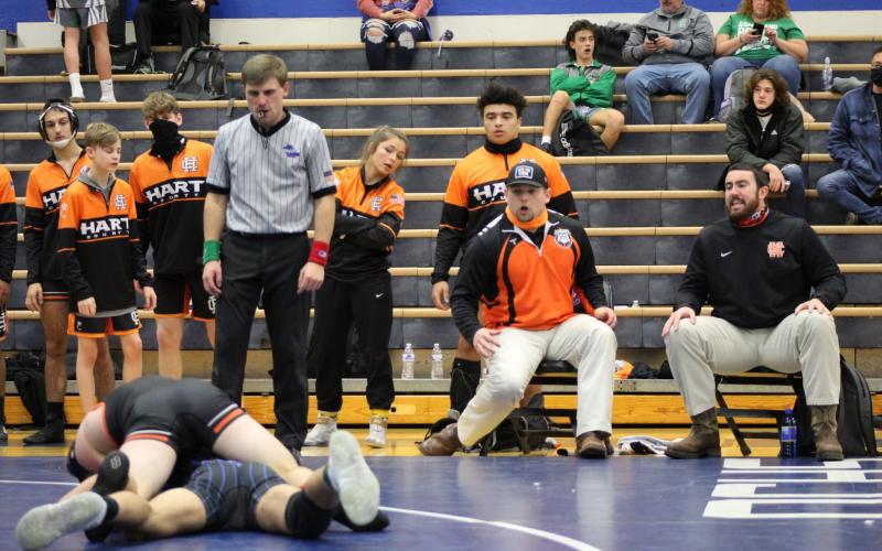 Photo by Mandy Patton - Hart County Head Coach Sean Gaddy, right, and assistant coach Matthew Patton, to Gaddy’s left, coach from a Hart County wrestler on Saturday, Jan. 16, at Oconee County High School.