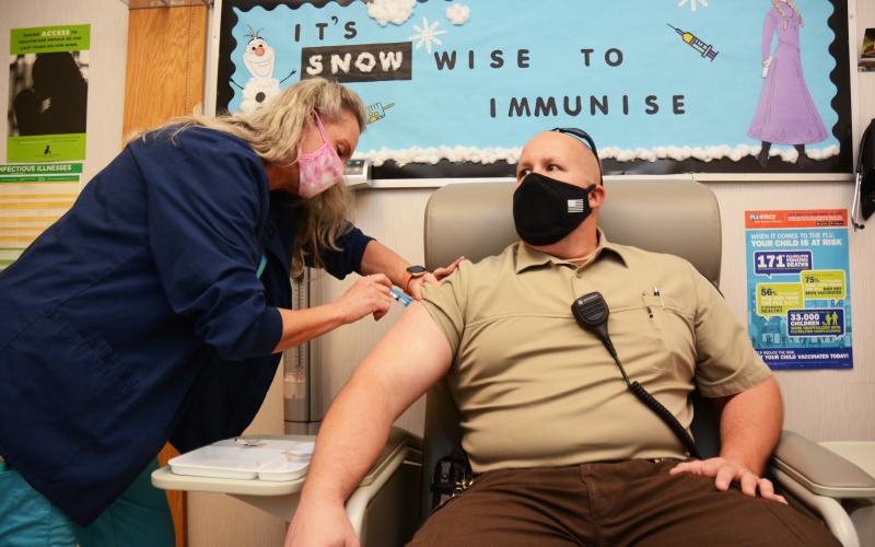 Sunshot by Michael Hall - Hart County deputy Brandon Peace gets a COVID-19 vaccine from Hart County Health Department nurse Elaine Fleming on Tuesday, Jan. 5 at the health department.