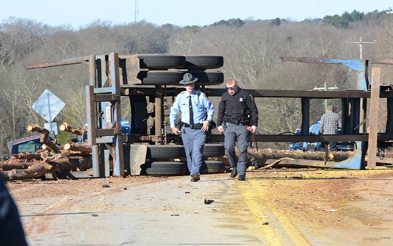 Two Georgia State Patrol troopers examine the site on Royston Highway where a log truck and a Ford Truck collided early Thursday morning, killing the driver of the Ford. 