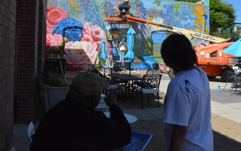 Color the World Bright director Joseph Norman, left, points out to associate project manager Alondra Arevalo, right, changes he wants made to the mural.