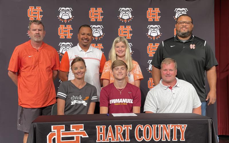 Photo submitted Chandler Smith, seated center, signed to Emmanuel College’s track team alongside, seated left, mother Tina Miller, seated right, stepfather Blake Miller, standing from left, coach Taz Dixon, coach Floyd Ramsey, sister Erin Miller and coach Kendell Rucker.