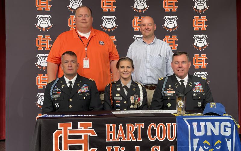 Evelyn Holmes, seated center, signed to the University of North Georgia JROTC program alongside, seated left, Lt. Col. Chris Carter, seated right, Col. Joshua D. Wright from UNG, standing left, principal Kevin Gaines and, standing right, Hart College and Career Academy CEO Brooks Mewborn.
