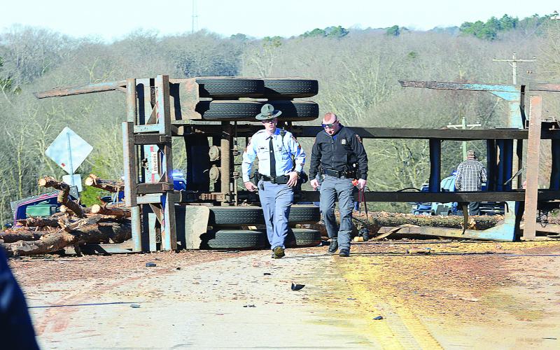 Sunshot by Michael Hall - Georgia State Troopers examine the scene of a log-truck crash on Thursday, March 4, that killed a Royston man.