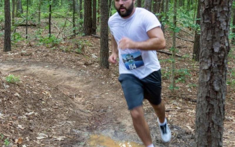 uchanan runs through the woods during an obstacle race in Winder.