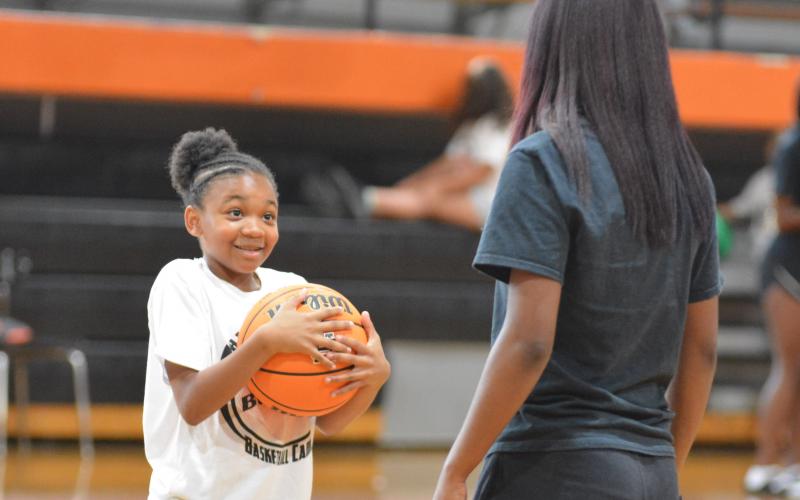  Dakota Wiley receives instruction from rising senior basketball player Kiyasia Montgomery. 