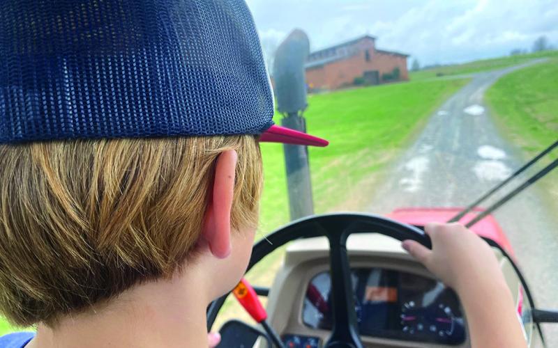 Nine-year-old Bayard, son of Eric and Connell NeSmith, takes us on a ride around the farm in our diesel tractor with an enclosed cab. 