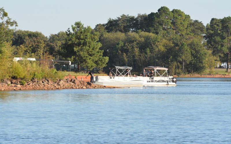 Dan Hunt/The Hartwell Sun Authorities working on an objective to recover a plane and its pilot from the depths of Lake Hartwell on Thursday, Sept. 15 come ashore at the Long Point Recreation Area ramp after extracting the pilot, who had been under water for five days. 