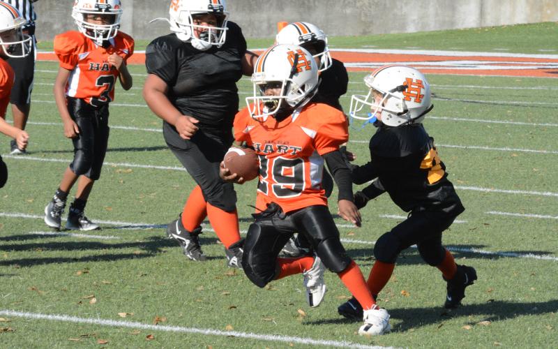 Kendrick Jones, ball carrier for one of the two 7-under Hart County rec teams makes his way up field Saturday at Herndon Stadium. Team Wise (black) defeated Team Wiley (orange) in a hard fought defensive battle, 6-0.