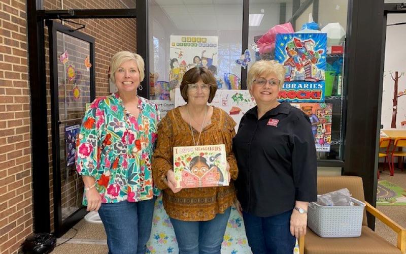 Hart County Farm Bureau Office Manager Tina Simmons, right, and  Hart EMC, Angie Brown, left, recently presented a copy of the children’s ag book “I Love Strawberries” to Pam Cole who accepts the book for the Hart County Public Library. The donation was made on behalf of the Georgia Foundation for Agriculture and Georgia EMC. 