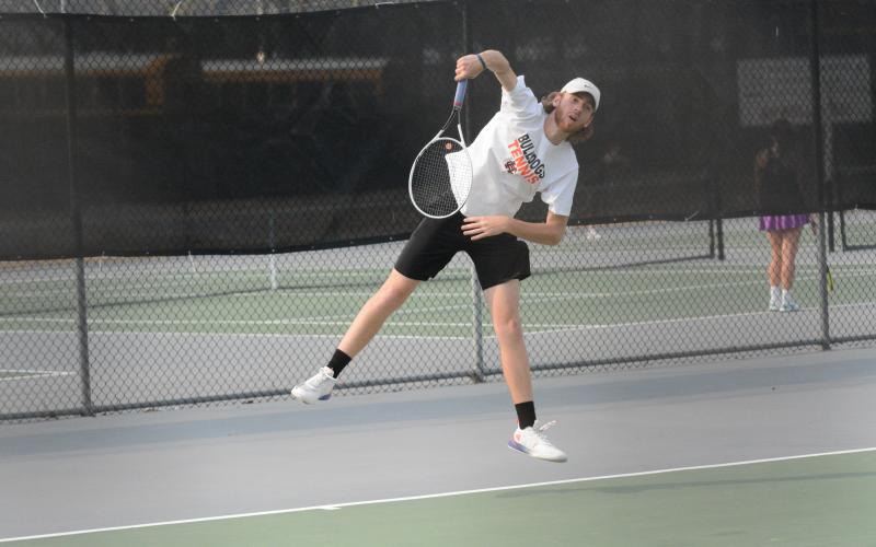 Senior Daniel Leard serves to a Franklin County Lion in Monday’s home match as the boys fell 5-0 and the girls won 3-2.
