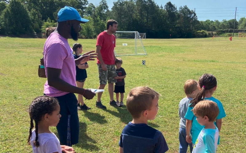 Bell Family YMCA sports director Kurve Augustine (pictured left with the hat) with kids during the second annual Healthy Kids Day on April 22.
