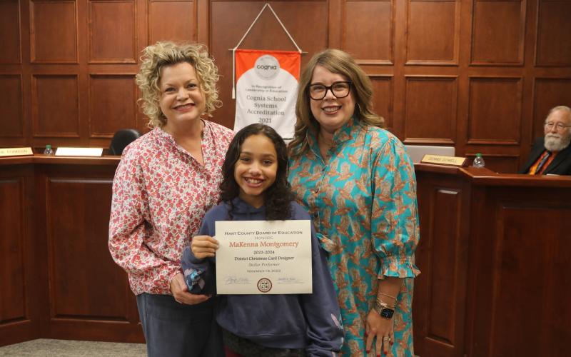 North Hart Elementary School student MaKenna Montgomery was recognized for creating the district’s annual Christmas card. From left to right: Superintendent Jennifer Carter, MaKenna Montgomery, and board chair Kim Pierce