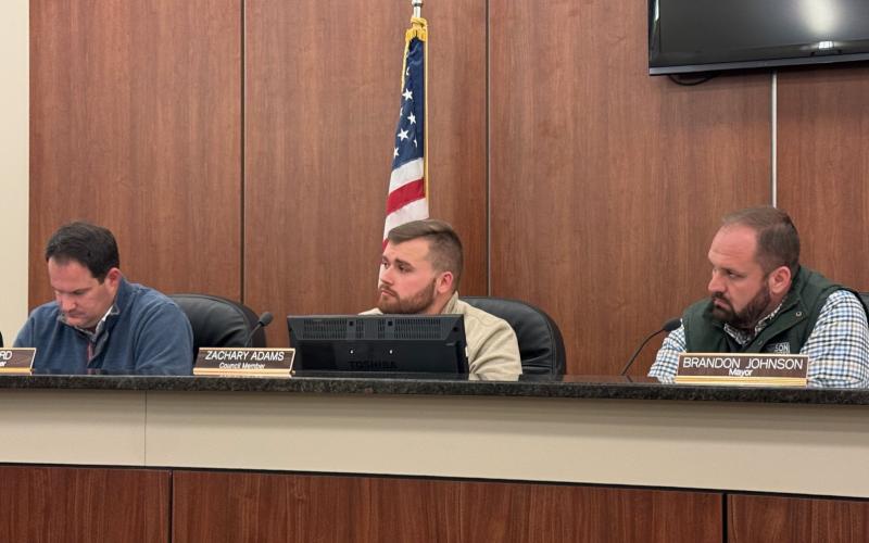 Council members (from left to right) Dan Leard, Zach Adams, and mayor Brandon Johnson hear debate on local alcohol license 