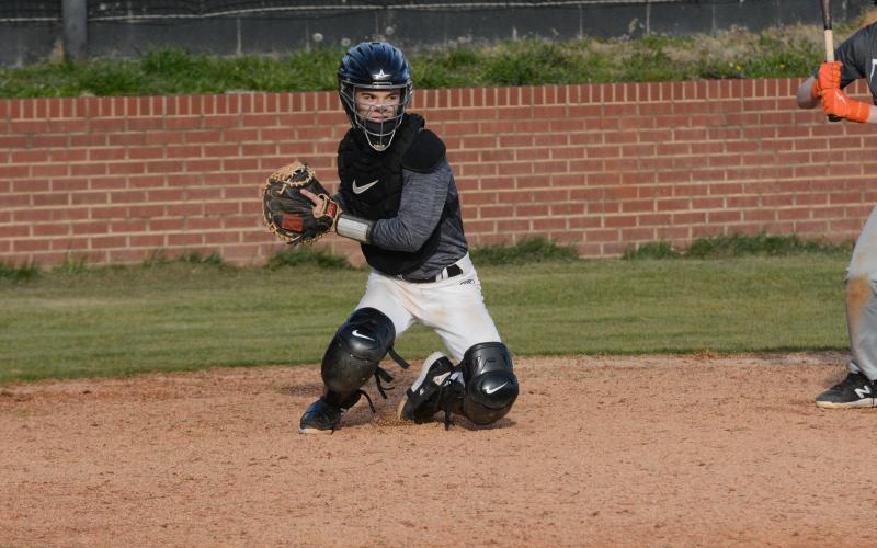 Pictured is junior catcher Pierce Mewborn as he gears up to throw the runner out at first base.