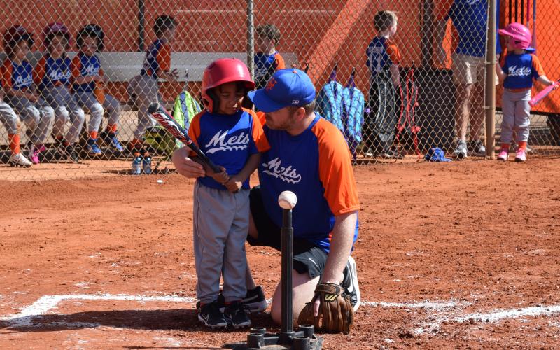 Pictured from left is Waltrevion Bowen being comforted by his coach Daniel Mitchell as he gets ready to bat during Hart County Little League’s Opening Day on March 16.