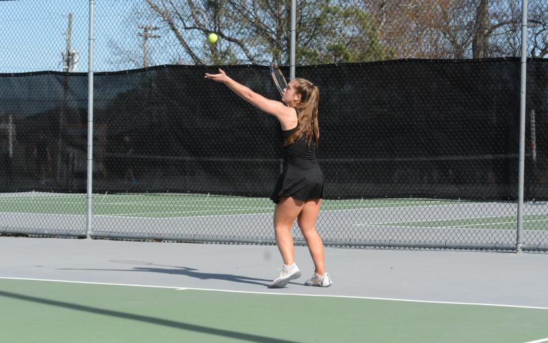 Senior Dakota Phillips gets ready to serve the ball into play, as she captured a win at No. 1 singles against the Lions of Hebron Christian on March 7.