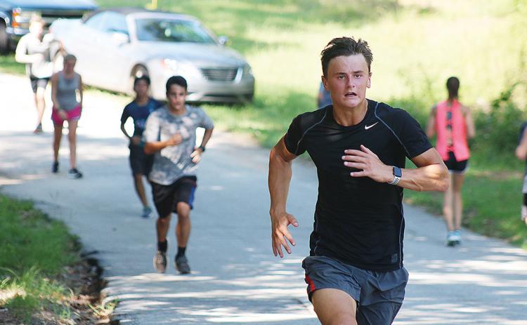 Sunshot by Grayson Williams — AJ Johnson runs up a hill recently at Hart County High School cross country practice. 