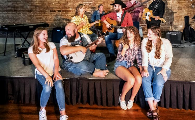 Sunshot by Bill Powell Pictured are Nash McCan and the McCan Family Band. Front row: Ella Long, Seth Howard, Victoria Evans amd Olivia Berry. Second row:  Andrea Bradford and Nash McCan (Josh Bryan). Back Row:  Kevin Long, Casey Middlebrooks and Jody DiMarco. Not Pictured: David Phillips and Jamee Floyd.