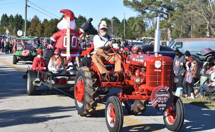 A gentleman takes his tractor along Montevideo Road Sunday at the annual Montevideo Christmas parade. 