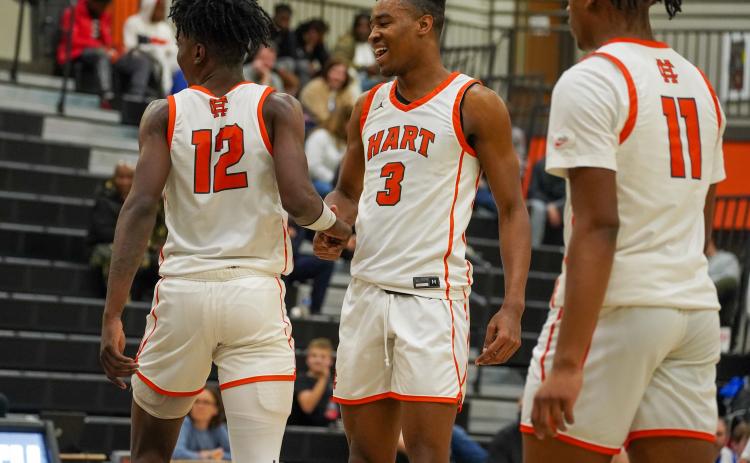 Pictured left to right: senior Terrance Mitchell, senior Tahj Johnson, and junior Jashon Gaines celebrating the 68-55 home win over the Warriors of Oconee County on Friday, Jan. 19. (Photo by Lexie Wheless)