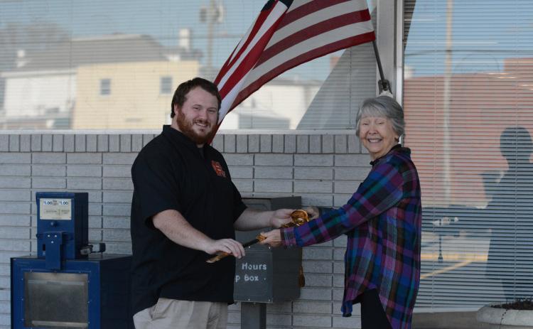 Joyce Kilpatrick (right) presents Hartwell resident Sam Simpson (left) with a Navy officer ceremonial sword that originally belonged to his late grandfather. Kilpatrick bought the sword at an auction before doing some investigating and returning it to its family.   